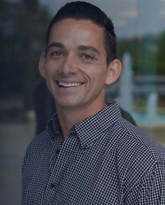 Jack Chinchay, smiling, in a checked button-up